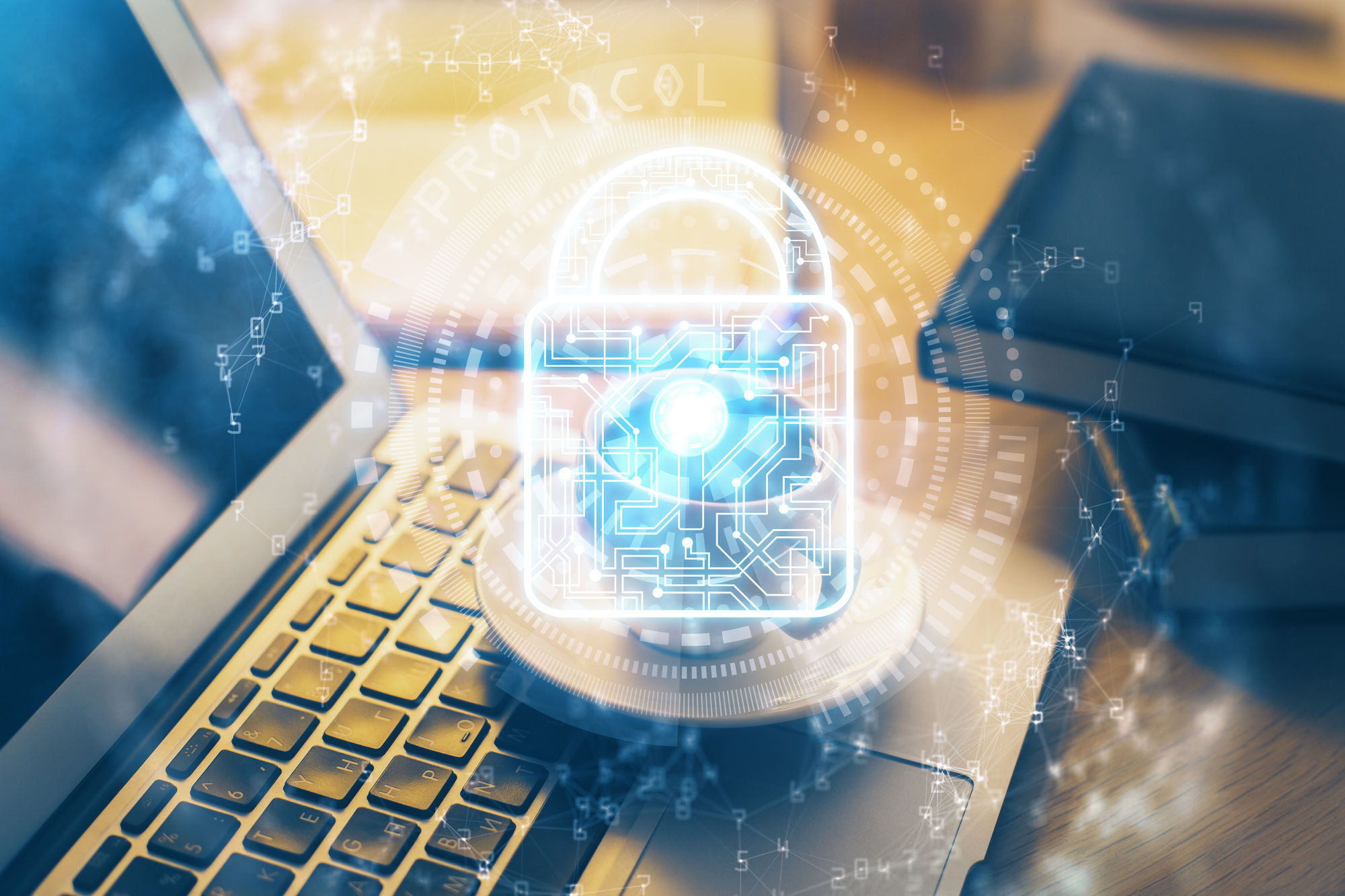 Double exposure of desk with laptop computer and lock icon hologram