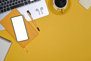 Smart phone, coffee, laptop computer and more against a yellow background